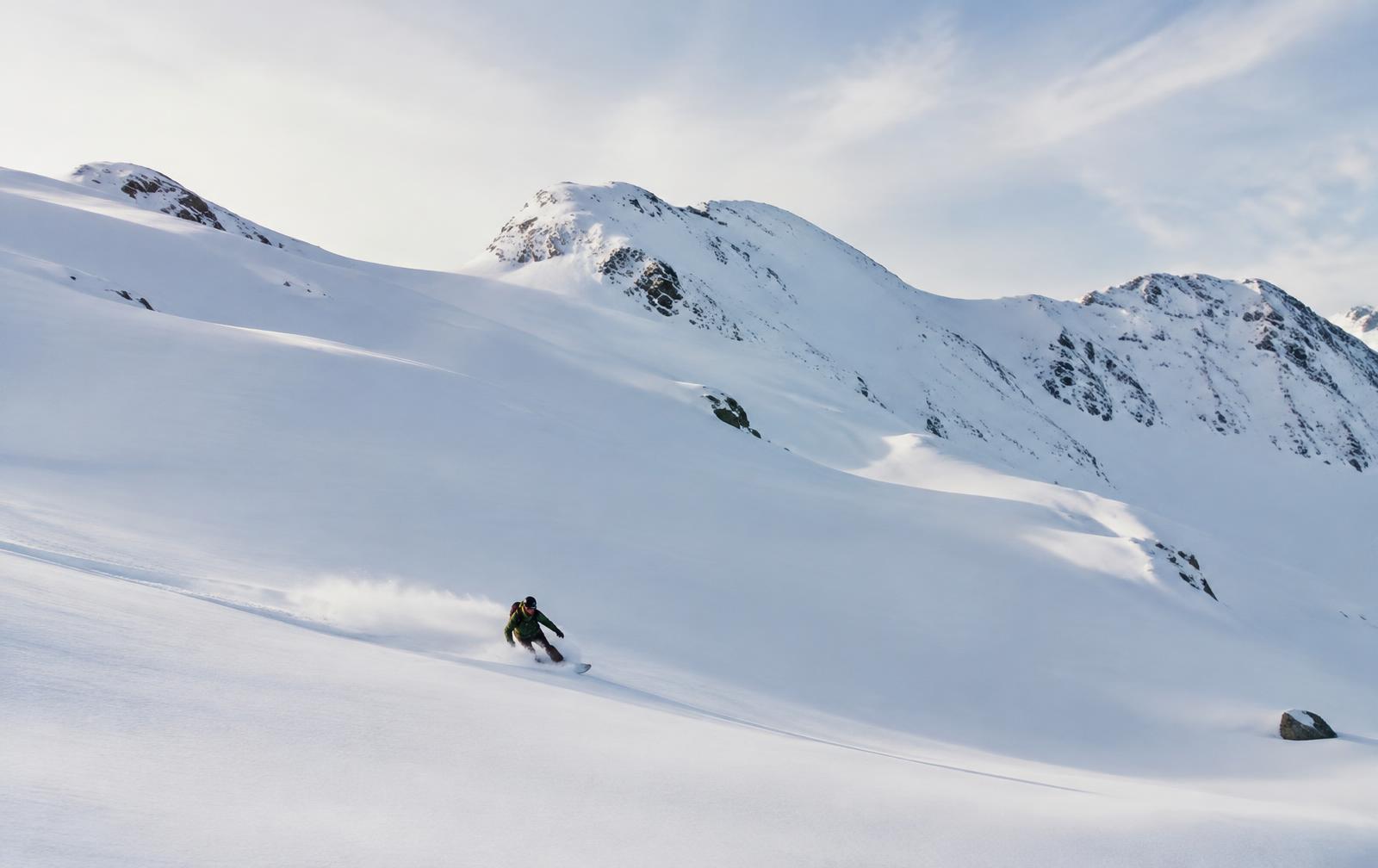 Snowboarder carving through fresh powder